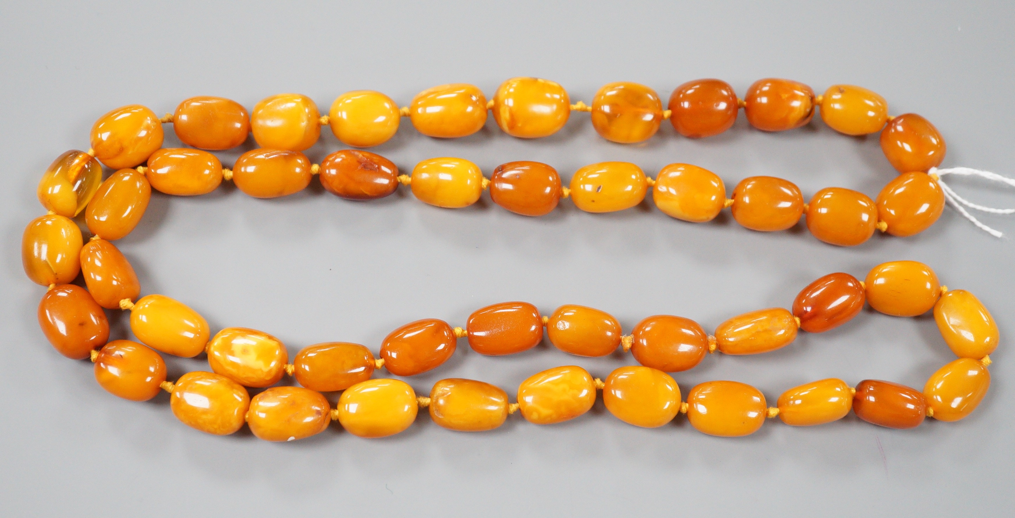 A single strand oval amber bead necklace, 90cm, gross 81 grams